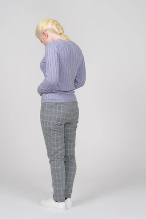 Three-quarter back view of a young woman looking down