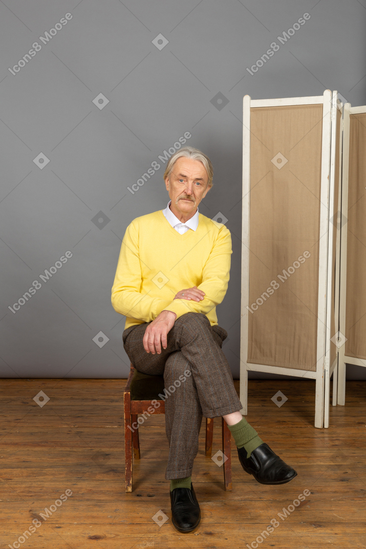 Man sitting cross-legged and looking at camera