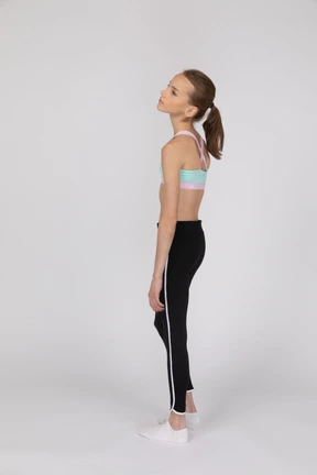 Side view of a teen girl in sportswear raising hand and arguing