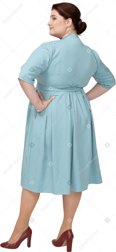 엉덩이에 손을 대고 포즈를 취하는 파란 드레스를 입은 여성의 뒷모습