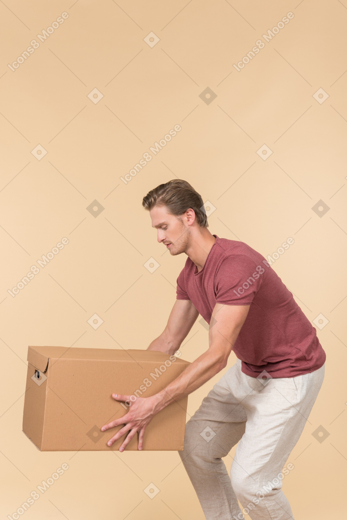 Delivery guy standing in profile and putting a parcel down