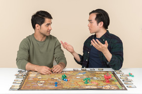 Amigos interraciales descubriendo algo mientras juegan juegos de mesa