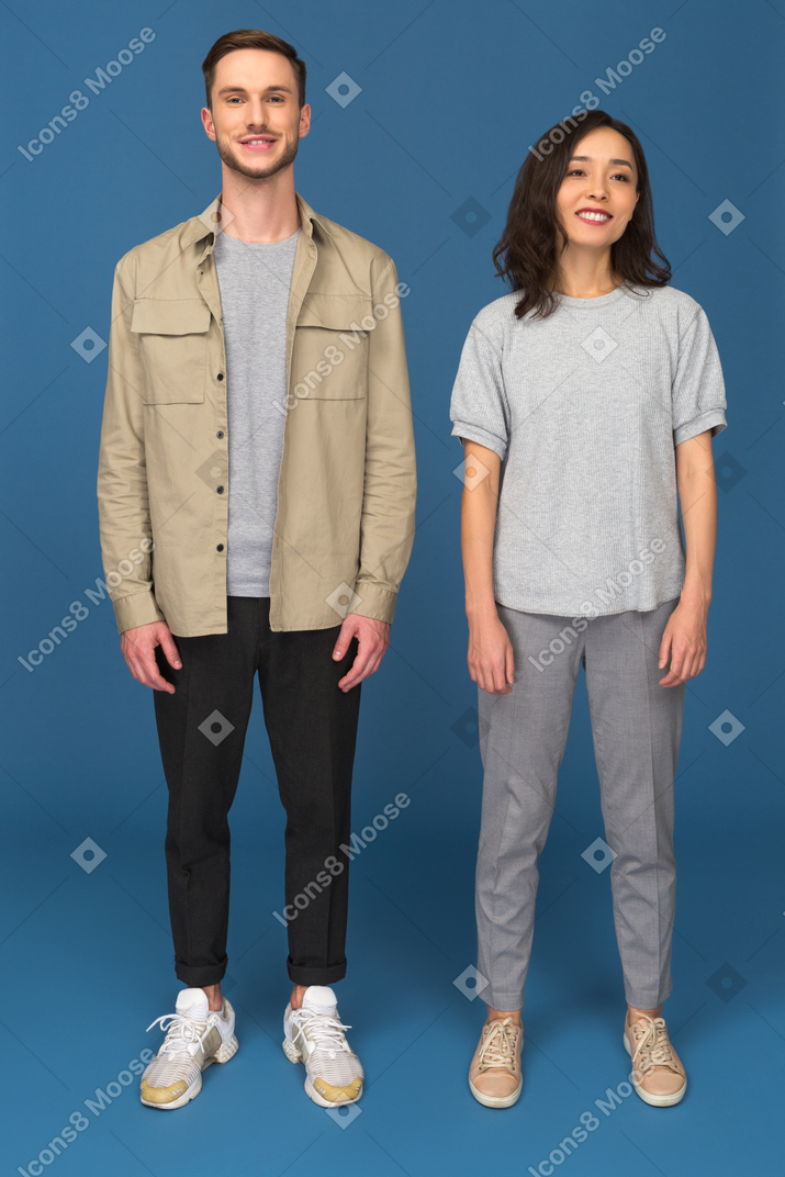 Young man and woman standing and looking at camera