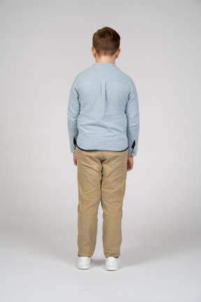 Rear view of a boy in casual clothes looking down