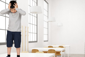 Overwhelmed boy standing on the desk