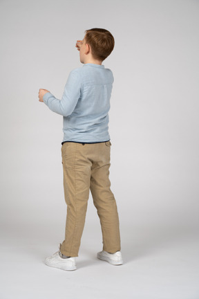 Back view of a boy standing and reaching for something