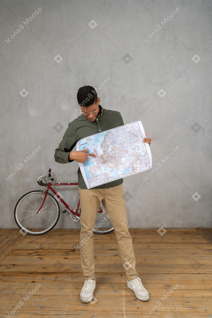 Front view of a man looking and pointing at a map
