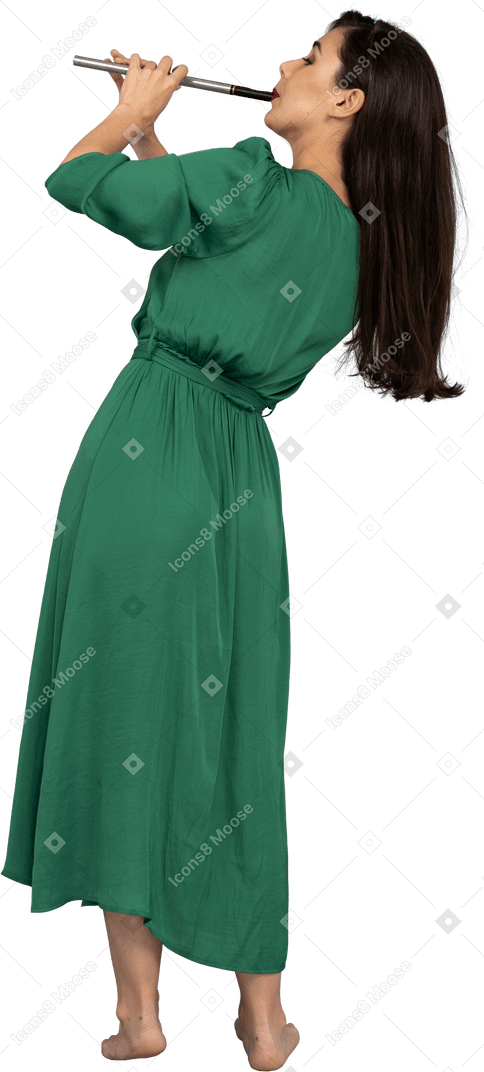 Vista posterior de una joven en vestido verde tocando la flauta mientras se inclina a un lado