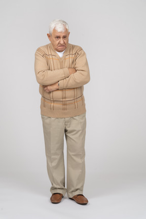 Vista frontal de un anciano con ropa informal de pie con los brazos cruzados