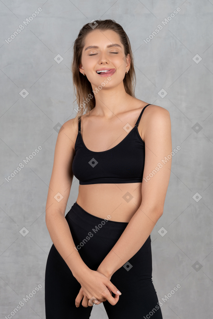 Young woman with eyes closed sticking out tongue