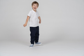 Three-quarter view of a boy standing and laughing happily