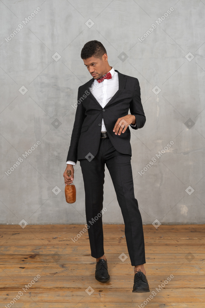 Intoxicated man walking with a bottle in his hand