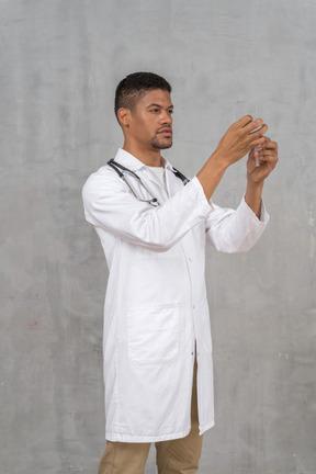 Male doctor preparing a syringe