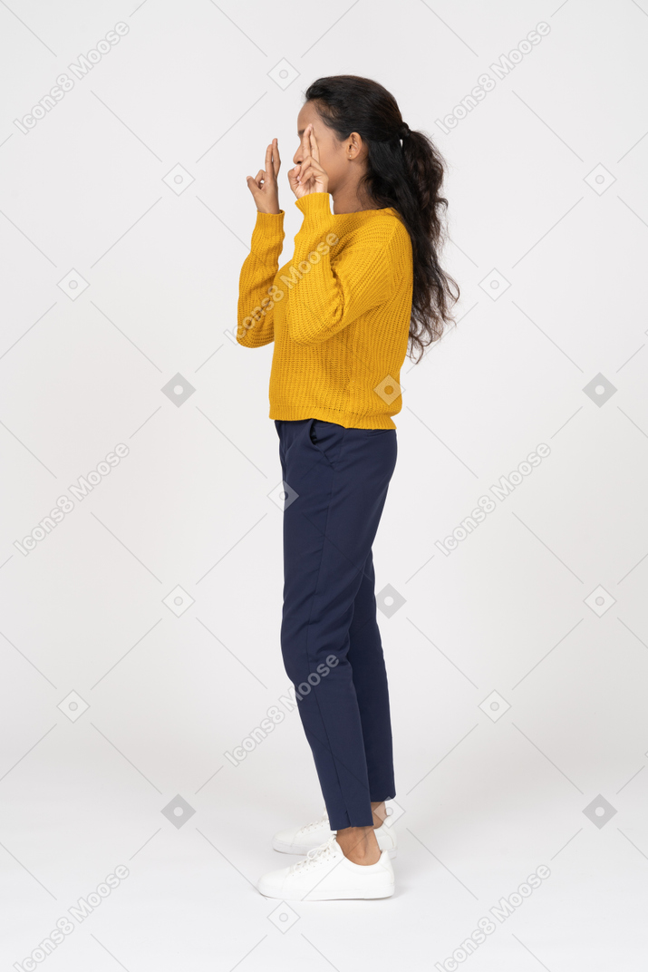 一个穿着休闲服的女孩用手指指着的侧视图