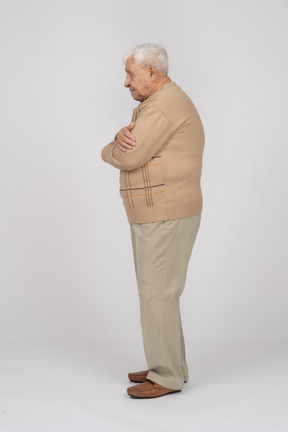 Vista lateral de um velho em roupas casuais, abraçando-se