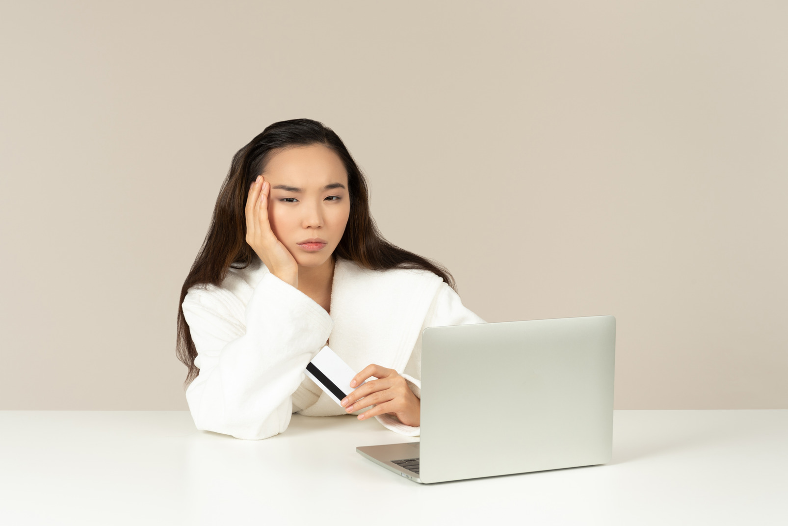 Upset young asian woman doing online shopping
