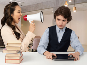 A woman yelling at a boy with a megaphone