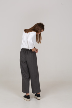 Back view of a young lady in office clothing adjusting her pants