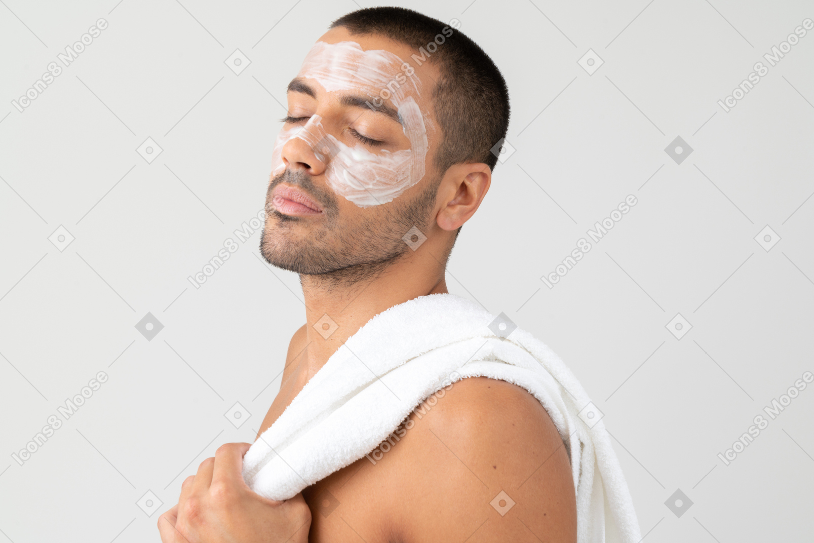 Man with facial mask with a towel on his shoulder