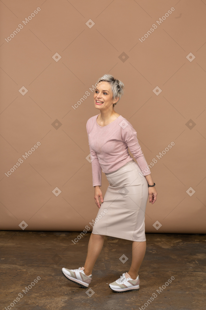 Vista frontale di una donna felice in abiti casual in piedi con la bocca aperta