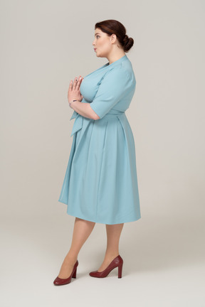 Side view of a woman in blue dress making faces