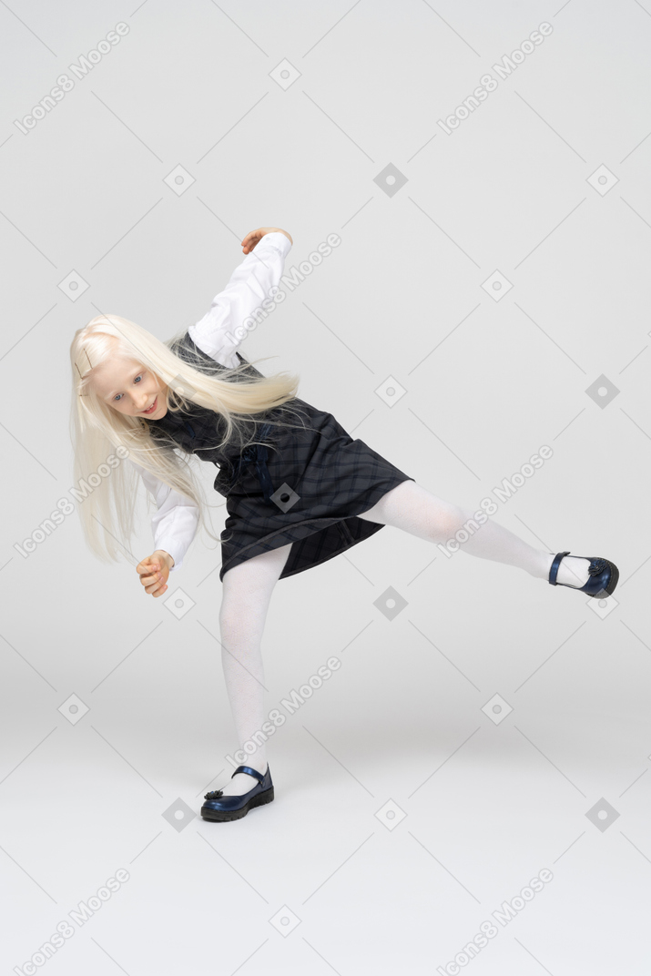 Schoolgirl bending sideways while dancing