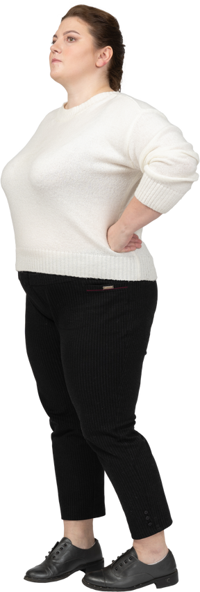 Confident plump woman in casual clothes standing with hands on hips