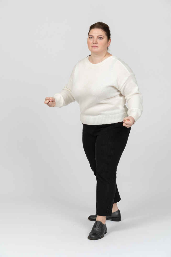 歩くカジュアルな服装のふくよかな女性 のフォト