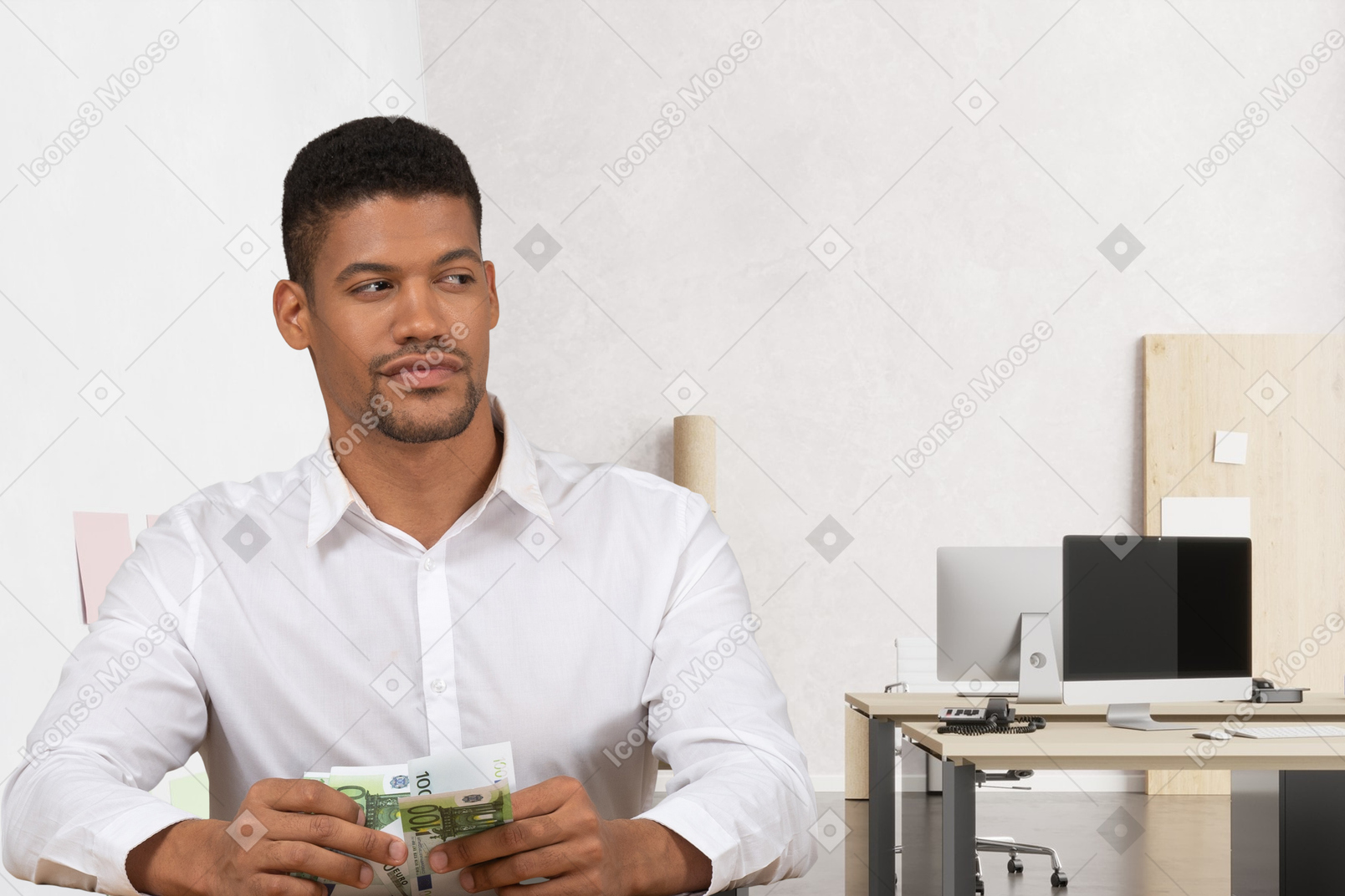 A man sitting at a desk holding a stack of money