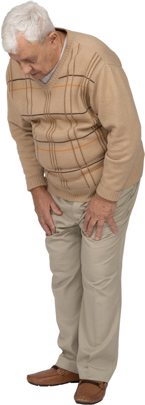 Front view of an old man in casual clothes looking down