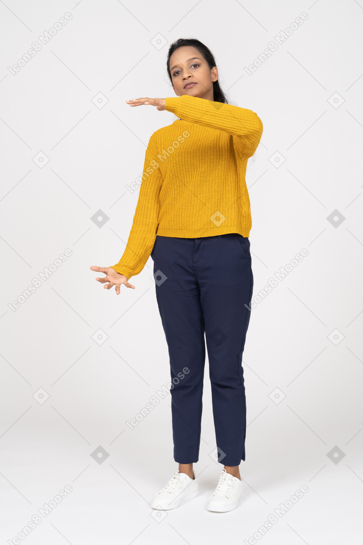 Vista frontal de uma garota com roupas casuais mostrando o tamanho de algo