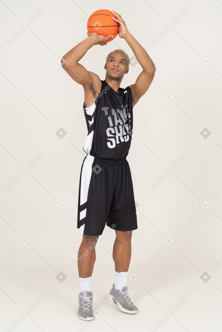 Vista frontale di un giovane giocatore di basket maschile che lancia una palla