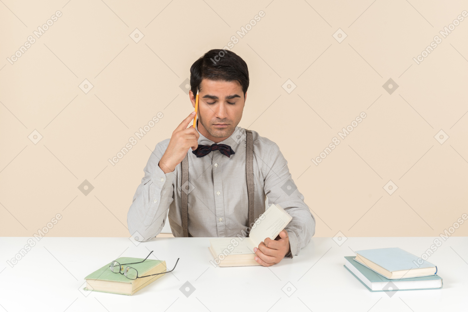 Estudiante adulto pensativo sentado en la mesa con libro abierto