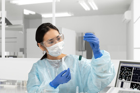 A woman in a lab coat holding a test tube