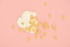 Scattered cereal hoops over spilled yoghurt