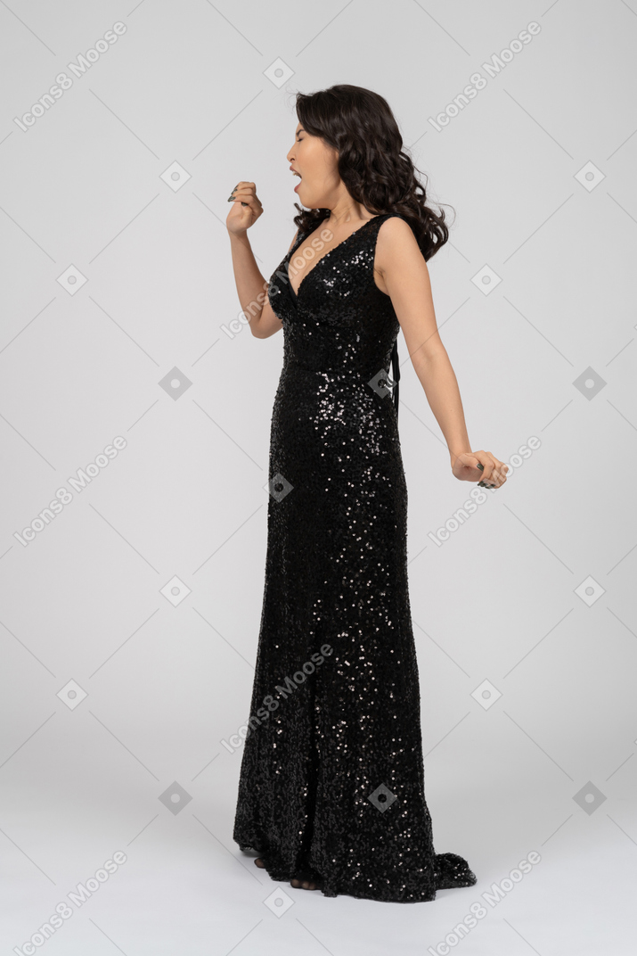 Mulher bonita cantando no vestido de noite preto