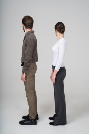 Side view of a young couple in office clothing turning away