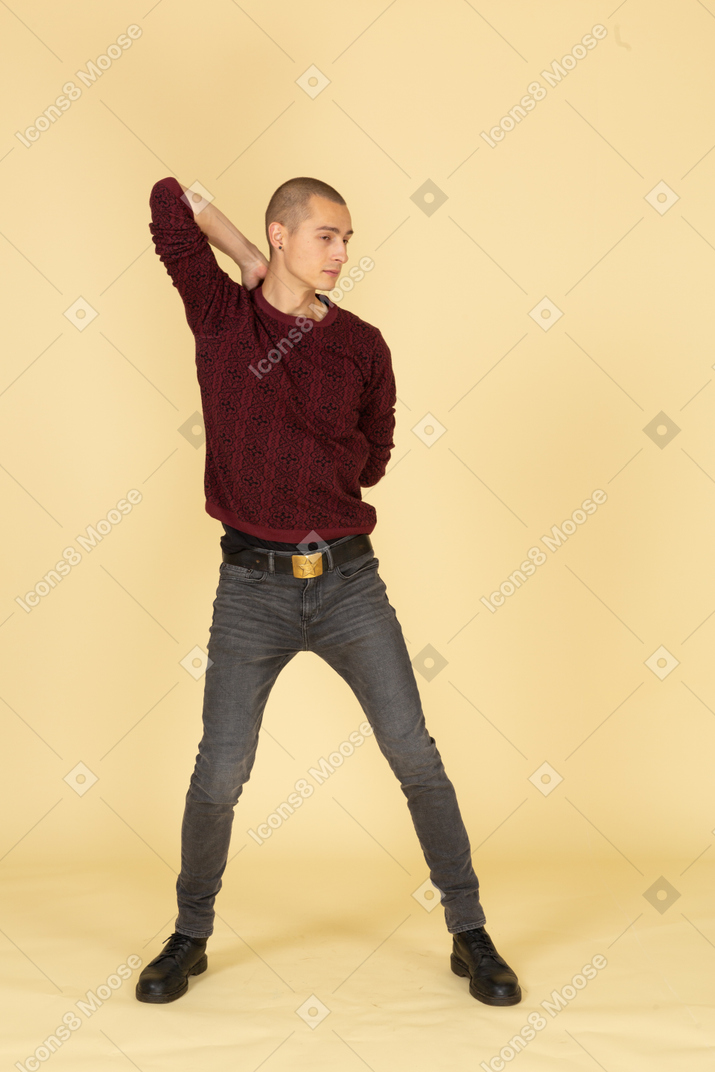 Front view of a young man in red pullover stretching his arms