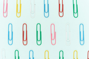 Colourful paper clips on blue background