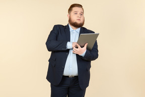 Joven oficinista con sobrepeso con tableta digital
