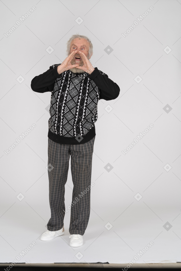 Homem sênior gritando com as mãos em concha em volta da boca