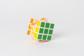 Un cubo de rubik rompecabezas acostado sobre un fondo blanco liso