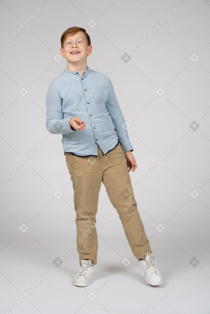 Front view of a happy boy balancing on one leg