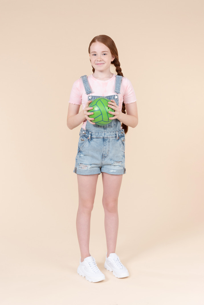 Smiling teenage girl holding green ball
