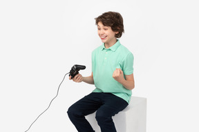 Teen boy celebrating his win in video game