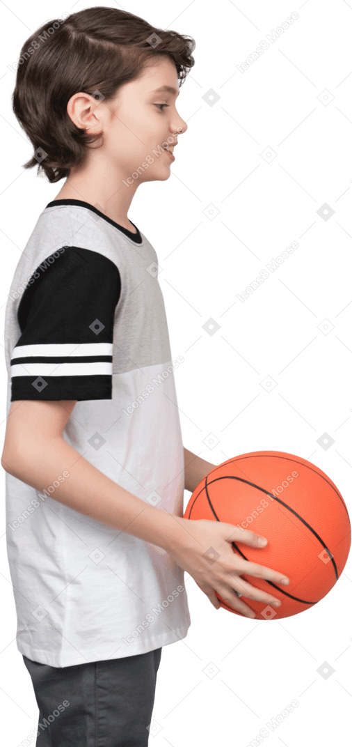 Side view of a boy holding a basketball ball
