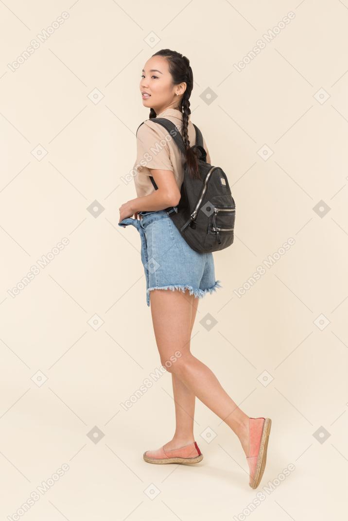 Jeune femme marchant avec sac à dos