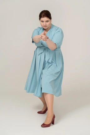 Vista frontal, de, un, mujer, en, vestido azul, actuación, arma de fuego, con, dedos