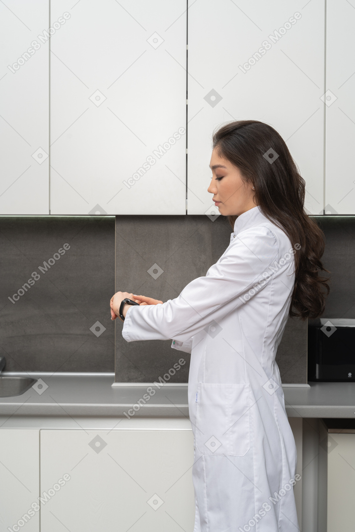 Side view of a doctor checking the time