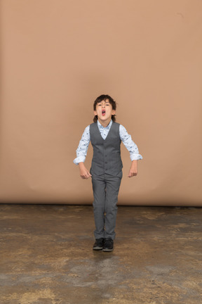 Front view of a cute boy in suit ready to jump